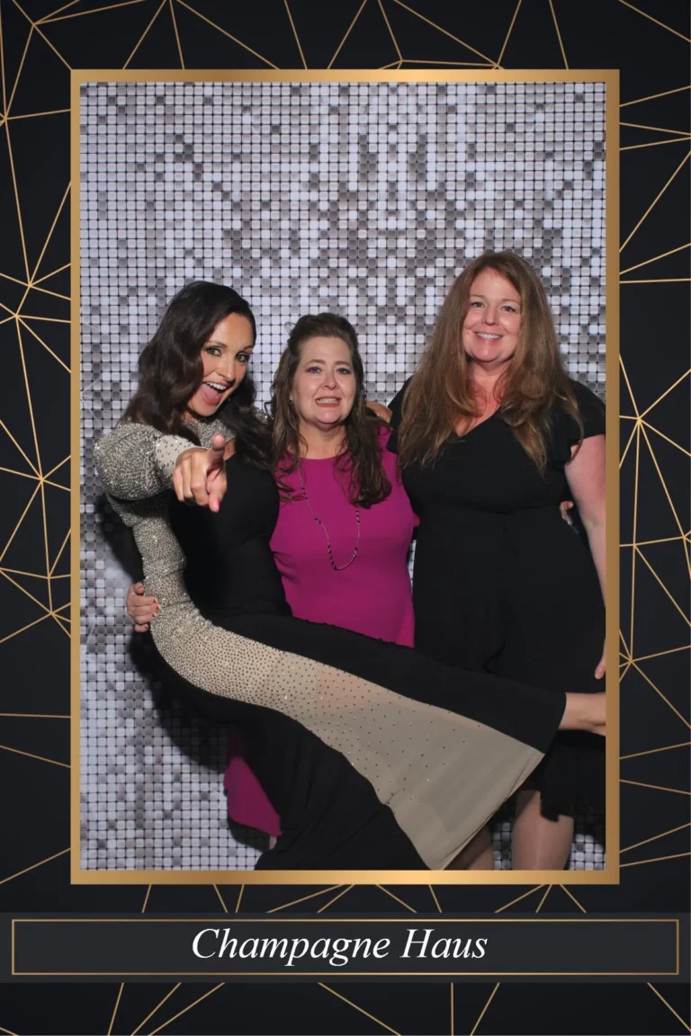 Photo booth print of three guests posing in a Champagne Haus branded gold frame template